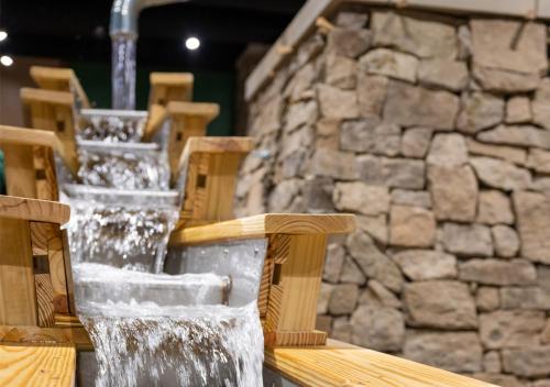 a water fountain in front of a stone wall at Country Cascades Waterpark Resort in Pigeon Forge