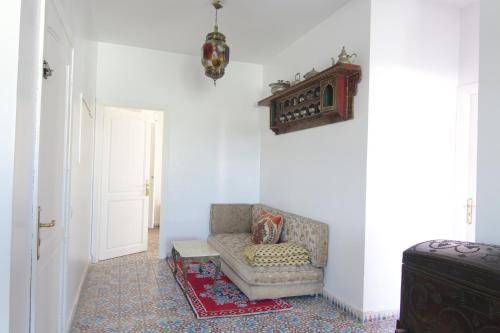 a living room with a couch and a white wall at zina surf house in Oualidia