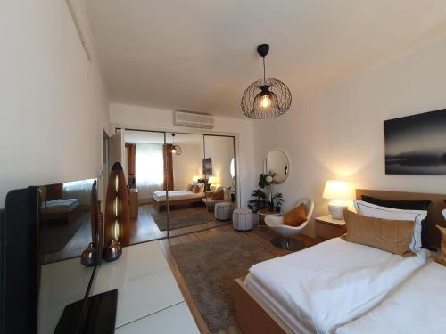 a bedroom with a bed and a living room at Apartman guru 3 Szeged in Szeged