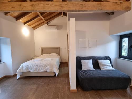 a bedroom with a bed and a couch at Casa de baixo studios in Arouca