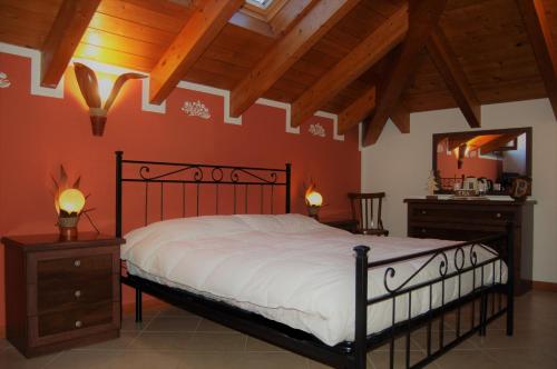 a bedroom with a large bed and a mirror at Narciso B&B Valbrona in Valbrona