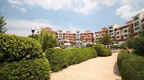 a walkway in a park with bushes and buildings at Аpartments Comfort -Marina Cape in Aheloy