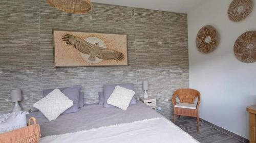 ein Schlafzimmer mit einem Bett und einem Bild eines Vogels in der Unterkunft Bel Canto - Chambres d'hôtes Plateau de sault in Roquefeuil
