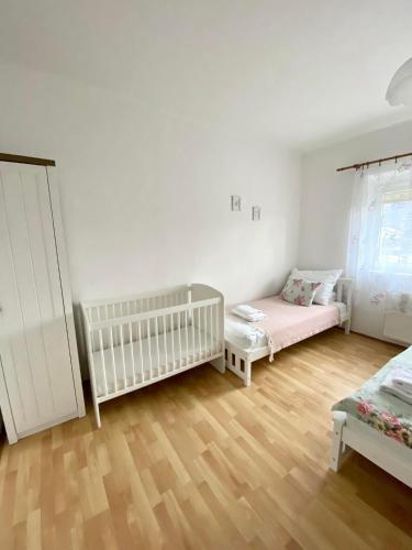 a room with two beds and a crib in it at Apartmán Markéta in Bystrzyca