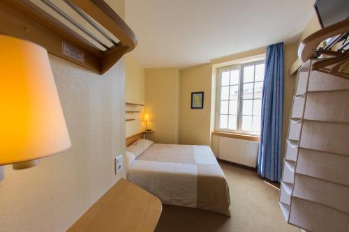 um quarto de hotel com uma cama e uma janela em Hôtel San Pedro em Saint Malo