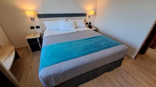 uma cama grande num quarto de hotel com duas lâmpadas em Hotel Diego de Almagro Temuco Express em Temuco