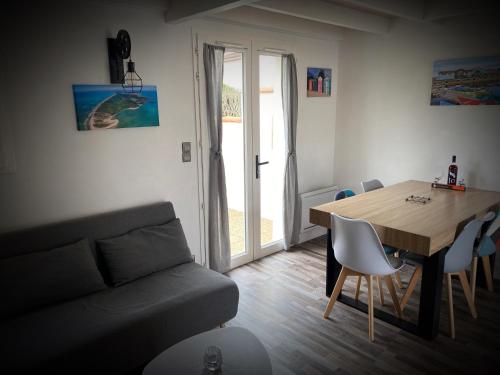 拉孔提涅的住宿－Maison à 300 m de la plage.，客厅配有桌子和沙发