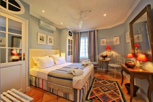 sypialnia z łóżkiem i biurkiem w obiekcie Le Vieux Logis w mieście Trémolat