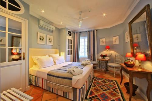 a bedroom with a bed and a desk in it at Le Vieux Logis in Trémolat