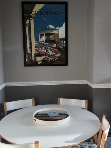 スカーバラにあるGranby House Holiday Apartments, Apartment 2, Formerly Sandy Palmsの白いテーブルと椅子、壁画