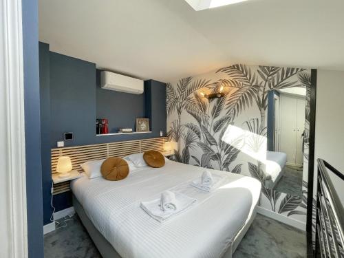 - une chambre avec un grand lit blanc et du papier peint tropical dans l'établissement Near Promenade 4 People, à Nice