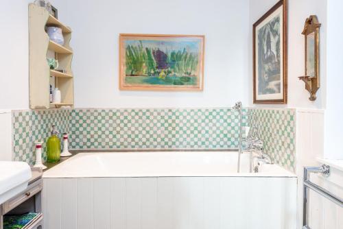 a bathroom with a bath tub and a sink at Gins Barn in Southampton