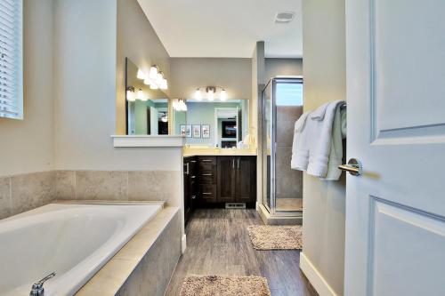 Un baño con bañera, lavabo y espejo. en Entrada at Moab 590 and 594, en Moab