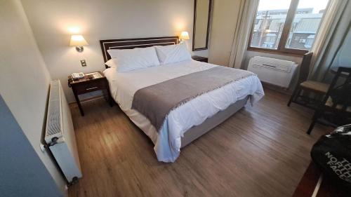 1 dormitorio con 1 cama grande y suelo de madera en Hotel Diego de Almagro Valdivia en Valdivia