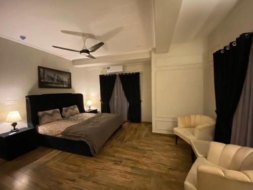um quarto com uma cama e uma ventoinha de tecto em De-Meridian Luxury Apartments em Rawalpindi
