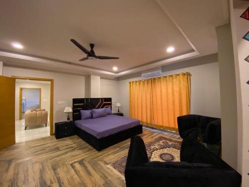 a bedroom with a bed and a couch at De-Meridian Luxury Apartments in Rawalpindi