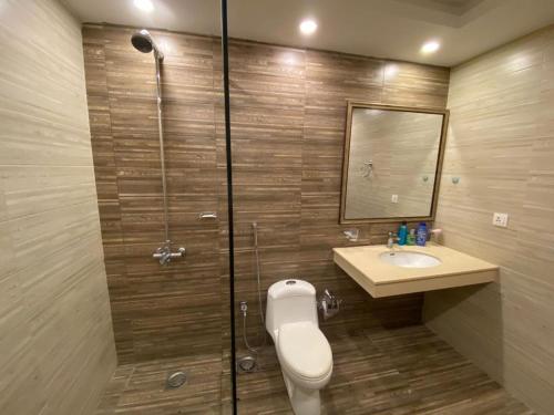uma casa de banho com um chuveiro, um WC e um lavatório. em De-Meridian Luxury Apartments em Rawalpindi