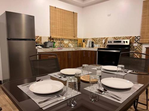 cocina con mesa con placas blancas y nevera en Orosi Mountain Lodge, en Orosí
