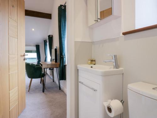 a white bathroom with a sink and a table at The Bay Tree in Penrith