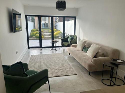 a living room with a couch and two chairs at Modern Townhouse in the heart of Beaumaris in Beaumaris