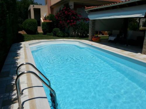 uma piscina num quintal com uma casa em Celestial Azure Villa, your Athenian Country House Retreat em Markopoulo Mesogaias