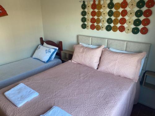 a room with two beds with pillows and a wall at Pousada Apartamento loft Braga in Cabo Frio