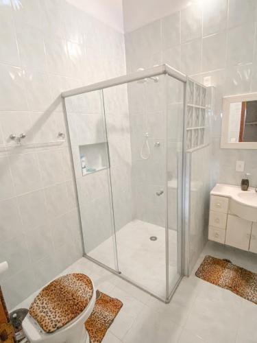 a bathroom with a shower with a toilet and a sink at Casa confortável com churrasqueira na Granja Viana in Carapicuíba