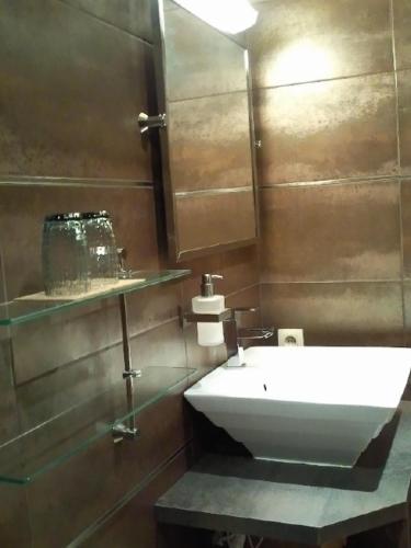 a bathroom with a white sink and a mirror at La Fiole Ambiance in Ferrières