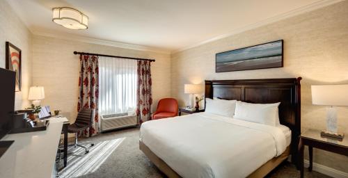 a hotel room with a bed and a desk and a chair at Ayres Hotel Costa Mesa Newport Beach in Costa Mesa