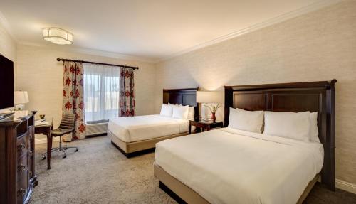 a hotel room with two beds and a desk at Ayres Hotel Costa Mesa Newport Beach in Costa Mesa