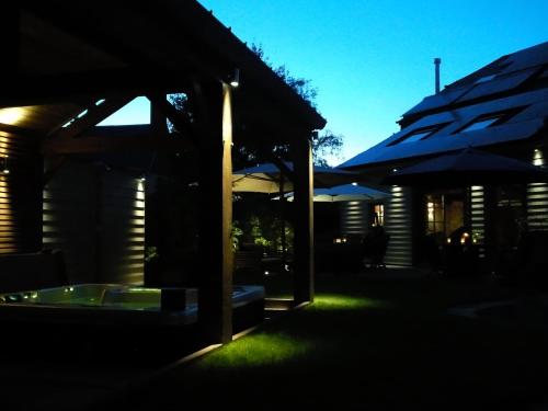 a night view of a patio with umbrellas at La Fiole Ambiance in Ferrières