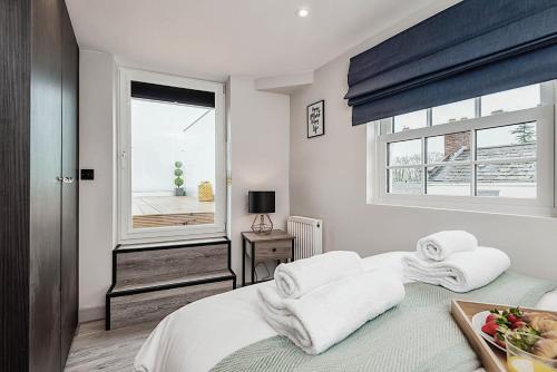 1 dormitorio con 1 cama con toallas en The Burton Penthouse, en Cheltenham