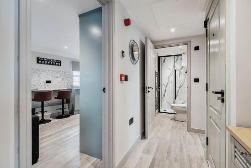 a hallway with a door leading to a bathroom with a sink at The Burton Penthouse in Cheltenham