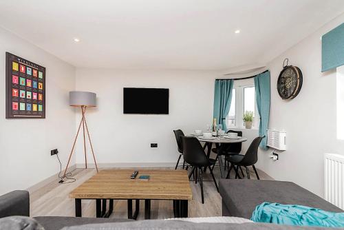 a living room with a table and a dining room at The Burton Penthouse by Fortuna Property Portfolio in Cheltenham