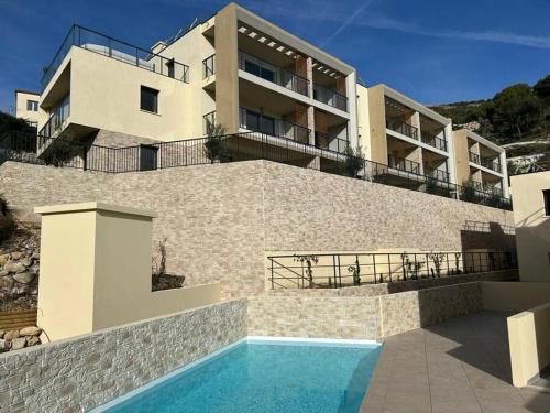 a building with a swimming pool in front of a house at Prestige View 411 in Èze