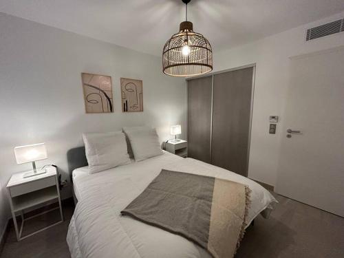 een slaapkamer met een bed met 2 tafels en een lamp bij Prestige View 411 in Èze