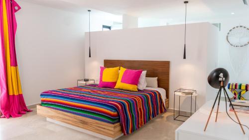 a bedroom with a bed with colorful blankets and pillows at Siaan Betine 4br Deluxe PDC in Playa del Carmen