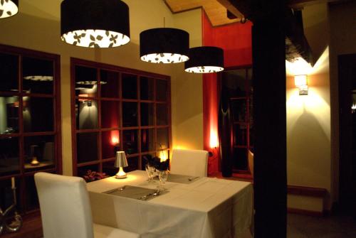 a dining room with a table and chandeliers at La Fiole Ambiance in Ferrières
