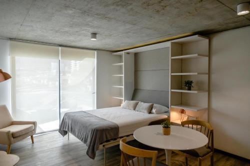 Prime Suites في أنتوفاغاستا: غرفة نوم بسرير وطاولة وكرسي
