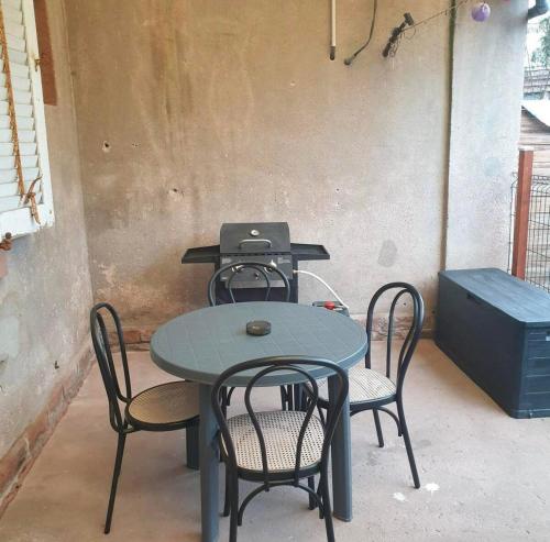 a table and chairs with a laptop on top of it at Appartement avec terrasse privative in Celles-sur-Plaine