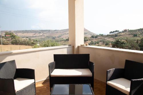 two chairs and a table on a balcony with a view at Casa California in Realmonte