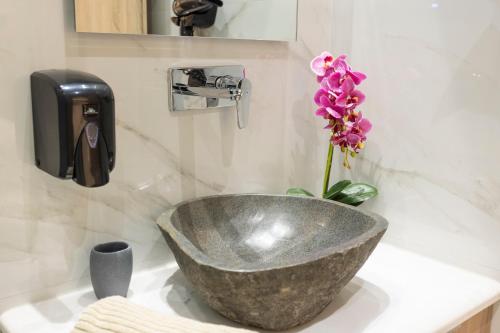 a bathroom sink with a large concrete bowl and a flower at Eva's House in Afitos