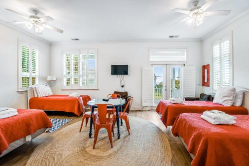 Cette chambre comprend 4 lits, une table et des chaises. dans l'établissement Vitamin Sea, à Folly Beach
