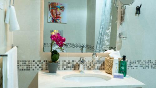 阿布扎比Your 1BR Retreat on Yas Island Blue Sapphire Apartment的浴室设有水槽,墙上挂有绘画作品