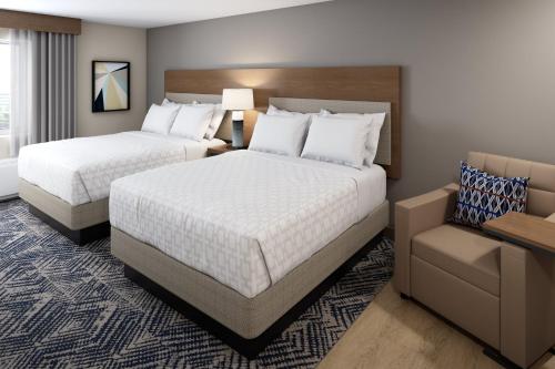 Pokój hotelowy z 2 łóżkami i krzesłem w obiekcie Candlewood Suites - Joliet Southwest, an IHG Hotel w mieście Joliet