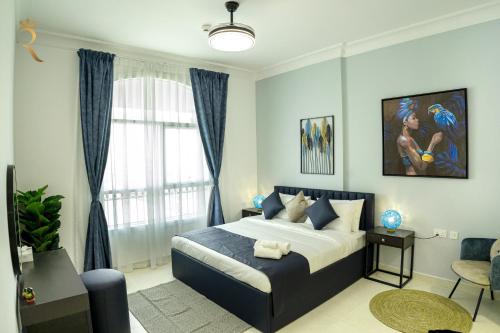 a bedroom with a king sized bed with blue curtains at Your 1BR Retreat on Yas Island Blue Sapphire Apartment in Abu Dhabi