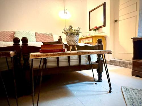 una sala de estar con una mesa con libros. en Freijoó Casa Vintage en Papantla de Olarte