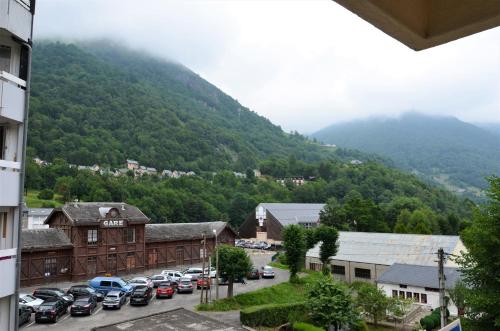 Un tas de voitures garées dans un parking en face d'une montagne dans l'établissement Mon petit nid à la montagne, à Cauterets