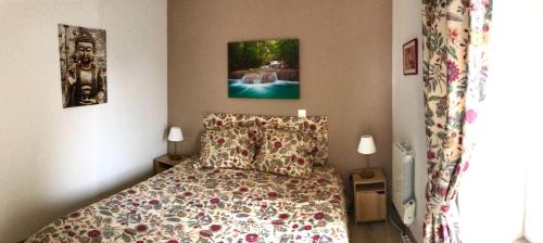 een slaapkamer met een bed met een bloemenbed bij Appartement très lumineux avec belle vue dégagée in Rochefort-en-Terre