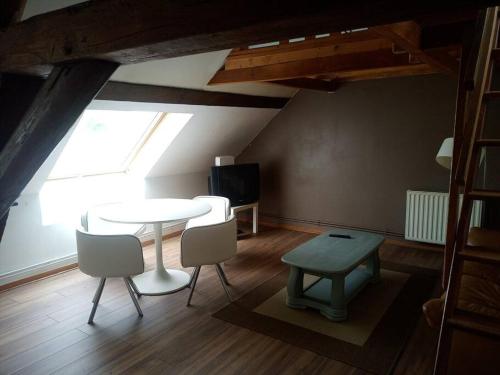 Zimmer mit einem Tisch, Stühlen und einem Fenster in der Unterkunft Terres de Saône in Écuelles